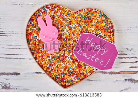 Sweets and Happy Easter card. Heart box on wooden background. Easter gift for girlfriend.