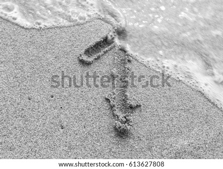 black and white picture sand number 1 by handwriting at the seaside beach swash
