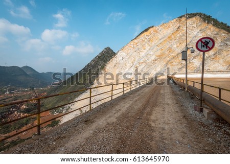gravel road and fence with broken hill as background