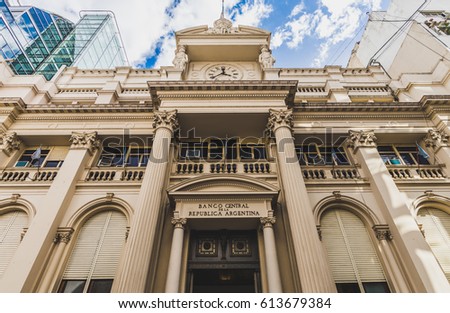 Building of the National Bank of Argentina in Buenos Aires on a sunny day against blue sky with white clouds. Photo stylized for film look Royalty-Free Stock Photo #613679384