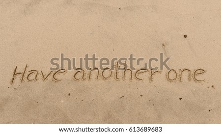 Handwriting words "Have another one" on sand of beach