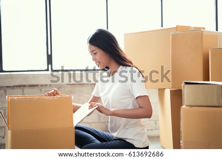 Asian woman pack the goods ordered online customers.