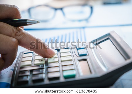 Calculator with hand man doing finance. Reflection light and fla