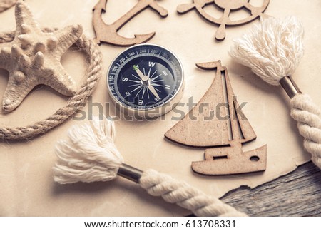 Compass, anchor, old paper with sea accessories. Background of a fascinating journey. 