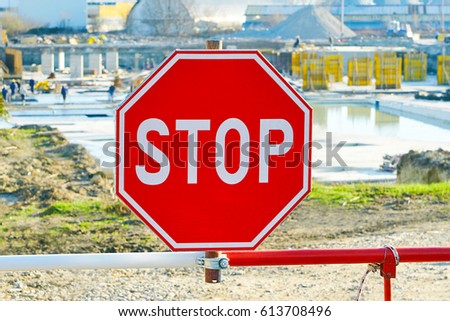 Construction of a resort hotel. Restrictive stop sign close-up. Builders at work on a sunny day                               
