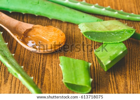 Aloe vera gel on wooden spoon with aloe vera on wooden table. Selective focus Royalty-Free Stock Photo #613718075