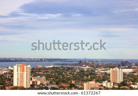 Still Picture of part of Hamilton, Ontario, Canada with industrial area and the Lake Ontario with silhouette of Toronto and CN Tower on background.