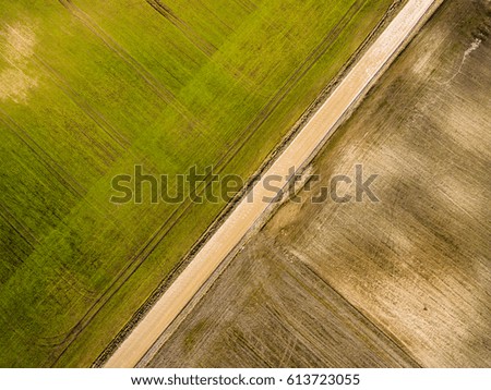 drone image. aerial view of rural area with freshly green fields, country roads and tractor tracks