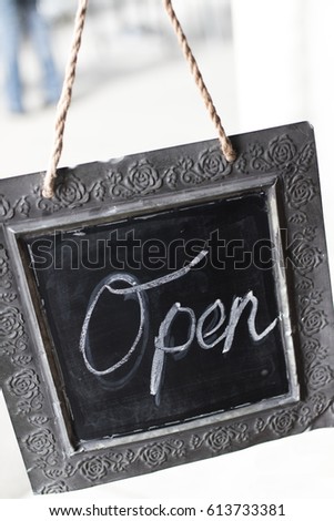 Rustic open sign hanging in glass door