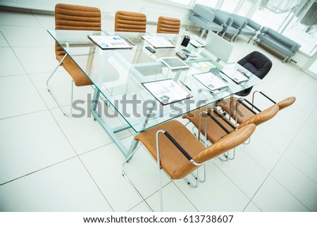 Desk for negotiations with the prepared financial charts and office equipment in the conference room before business meetings.