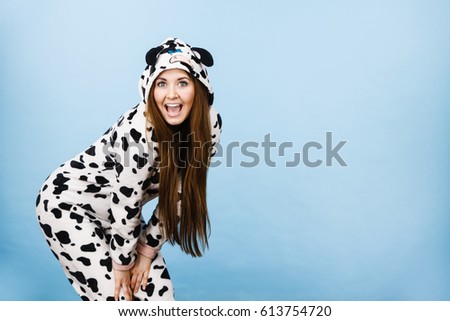 Happy teenage girl in funny nightclothes, pajamas cartoon style smiling, positive face expression, studio shot on blue.