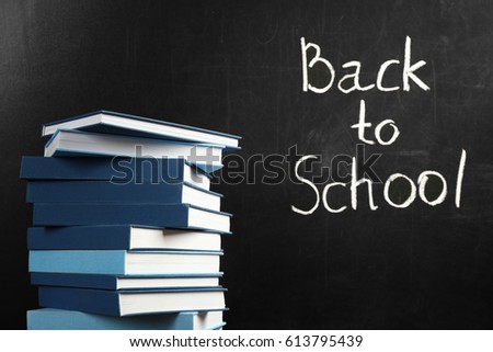 Books on blackboard background. Back to school concept