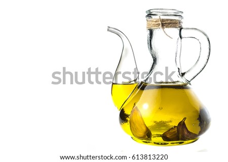 Extra virgin olive oil flavored with garlic in rustic glass jar isolated on white