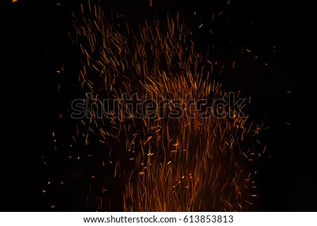 Photo of hot sparking live-coals burning, spark of bonfire.