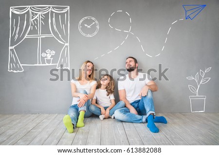 Happy family sitting on wooden floor. Father, mother and child having fun together. Moving house day, new home and design interior concept Royalty-Free Stock Photo #613882088
