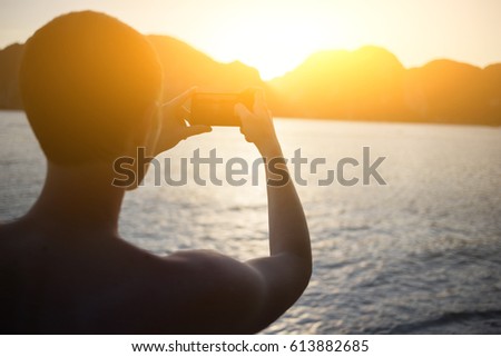 Man photographing standing on seashore