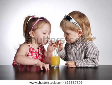 boy and girl drinking juice on bright background