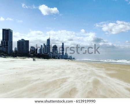 The beach with building tower on blue sky and sand on foreground