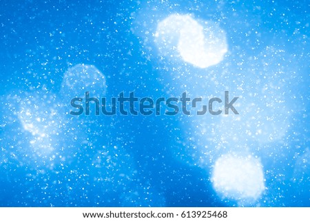 Abstract bokeh or glitter lights on blue  background. Circles and defocused particles. Design template