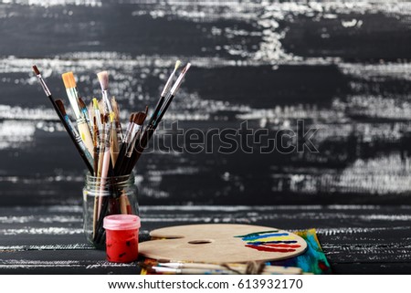 Artist's workshop. Top view of paintbrushes palette and acrylic paints with white canvas. Set of brushes and oil paints. Art picture with copy space and for add text.Items for children's creativity.