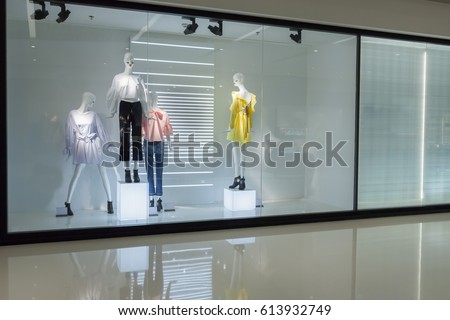 mannequins with dress in fashion store display window  Royalty-Free Stock Photo #613932749