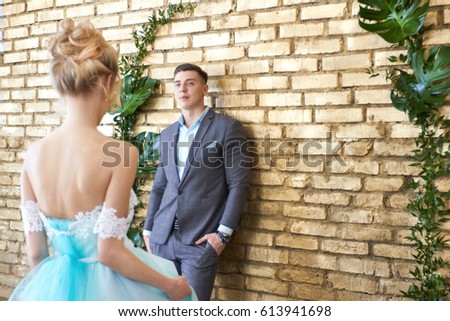 Newly married couple, loving couple before the wedding. Man and woman loving each other. The bride in the turquoise dress and groom in a blue suit. Wedding decor, wedding photo zone