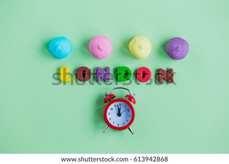 photo of tasty marshmallows, alarm clock and colorful letters on the wonderful green background