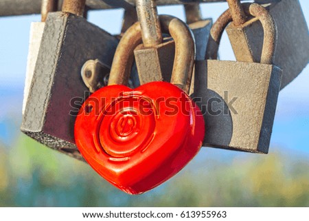 Beautiful heart with a key hanging on the railing of the bridge against the blue sky and the sea on a sunny day close up. Symbol of love. Valentine's Day                               