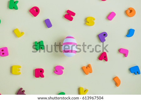 photo of cute Easter egg and colorful letters on the wonderful white background