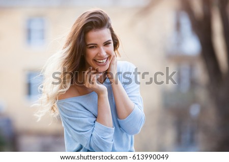 Outdoors portrait of beautiful young girl laughing Royalty-Free Stock Photo #613990049