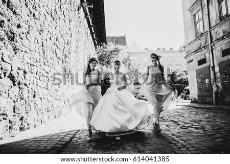The bride with bridesmaids walking along street