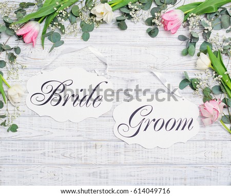 Bride and groom decoration boards with floral frame over wood, flat lay