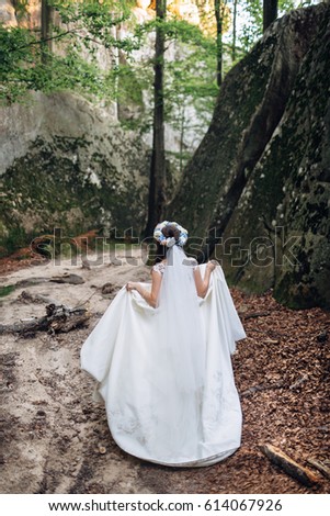 The charming bride walking along forest