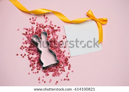 Easter postcard. Rabbit and pink decor on pink background Place for text. Colorful close up