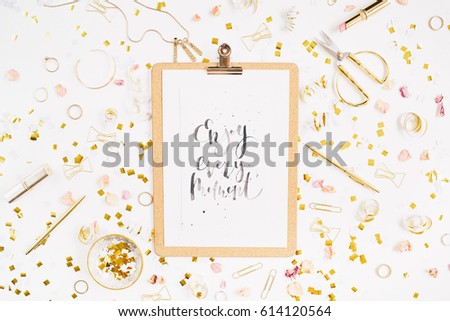 Beauty blog background. Quote Enjoy Every Moment, clipboard and gold style feminine accessories pattern. Golden tinsel, scissors, pen, necklace, bracelet on white background. Flat lay, top view.