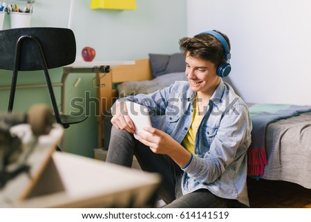 Teenage boy using tablet in his home. Royalty-Free Stock Photo #614141519