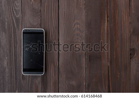 Broken phone on wooden background