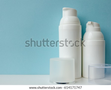 white cosmetic bottles on blue background