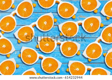 Orange sliced sunglasses on a blue rustic wood background, Summer fruit and fashion concept