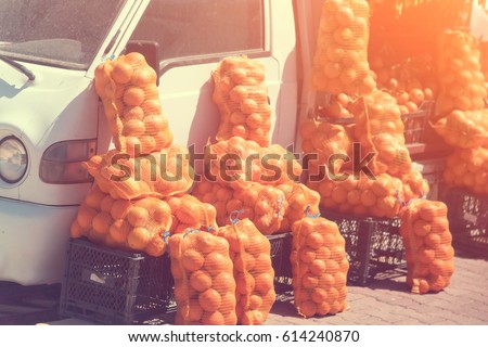 Bags of potatoes near the white car