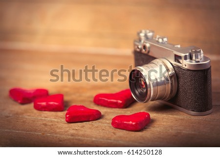 photo of heart shaped toys and retro camera on the wonderful brown wooden background