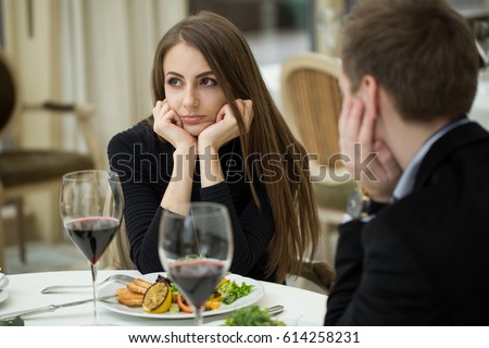 Young woman making an exasperated expression gesture on a bad date at the restaurant Royalty-Free Stock Photo #614258231