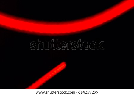 Red glowing stripes of abstraction on black for design