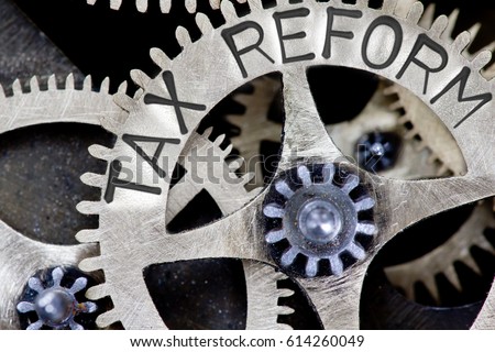 Macro photo of tooth wheel mechanism with TAX REFORM letters imprinted on metal surface