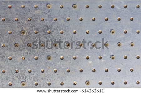 Texture of the metal plate with bolts and holes.