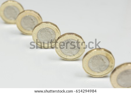 New British one pound sterling coins up close macro studio shot against a shiny reflective White background