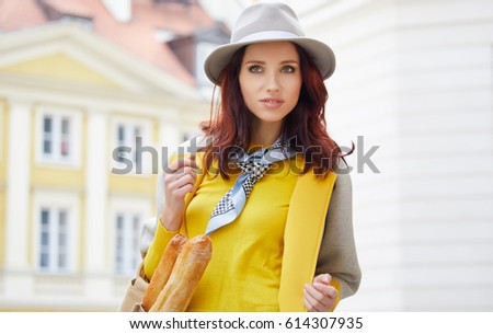 Woman with bread in a bag on the street of Paris