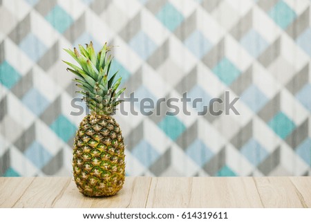 Pineapple on a wooden table over blue background. Juicy fresh ananas. Summer concept. Copy space.