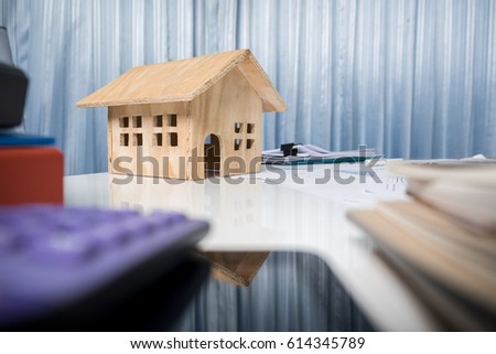 Business desk close up with house wood model.
