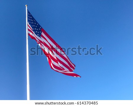 American flag waving in blue sky.